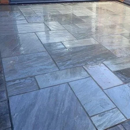 Close-up of wet stone or tile floor with reflections.