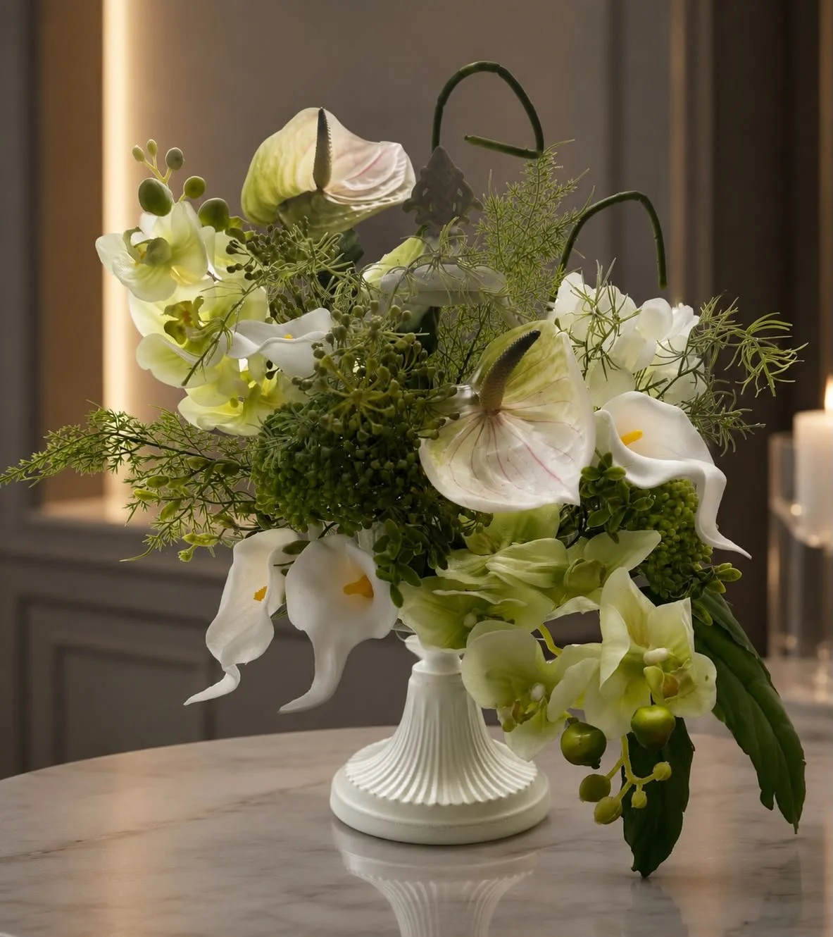 Elegant white and green floral arrangement in a fluted vase on a marble table