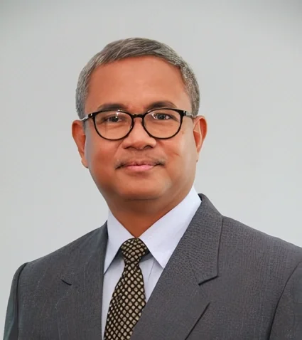 Professional man in a suit and glasses, posing with a confident expression.
