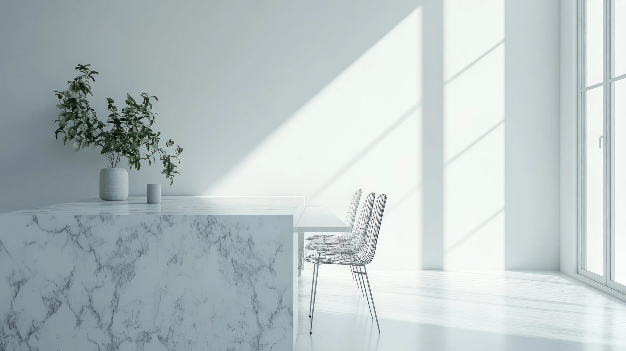 Minimalist kitchen scene with a white marble countertop, a potted plant, a small vase, a white wall with sunlight coming through a window, and wireframe chairs.