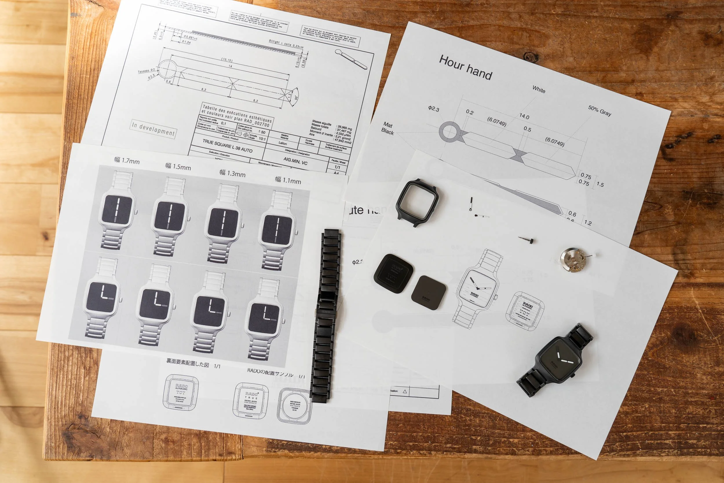 Overhead shot of Rado True Square watch components and product development sketches
