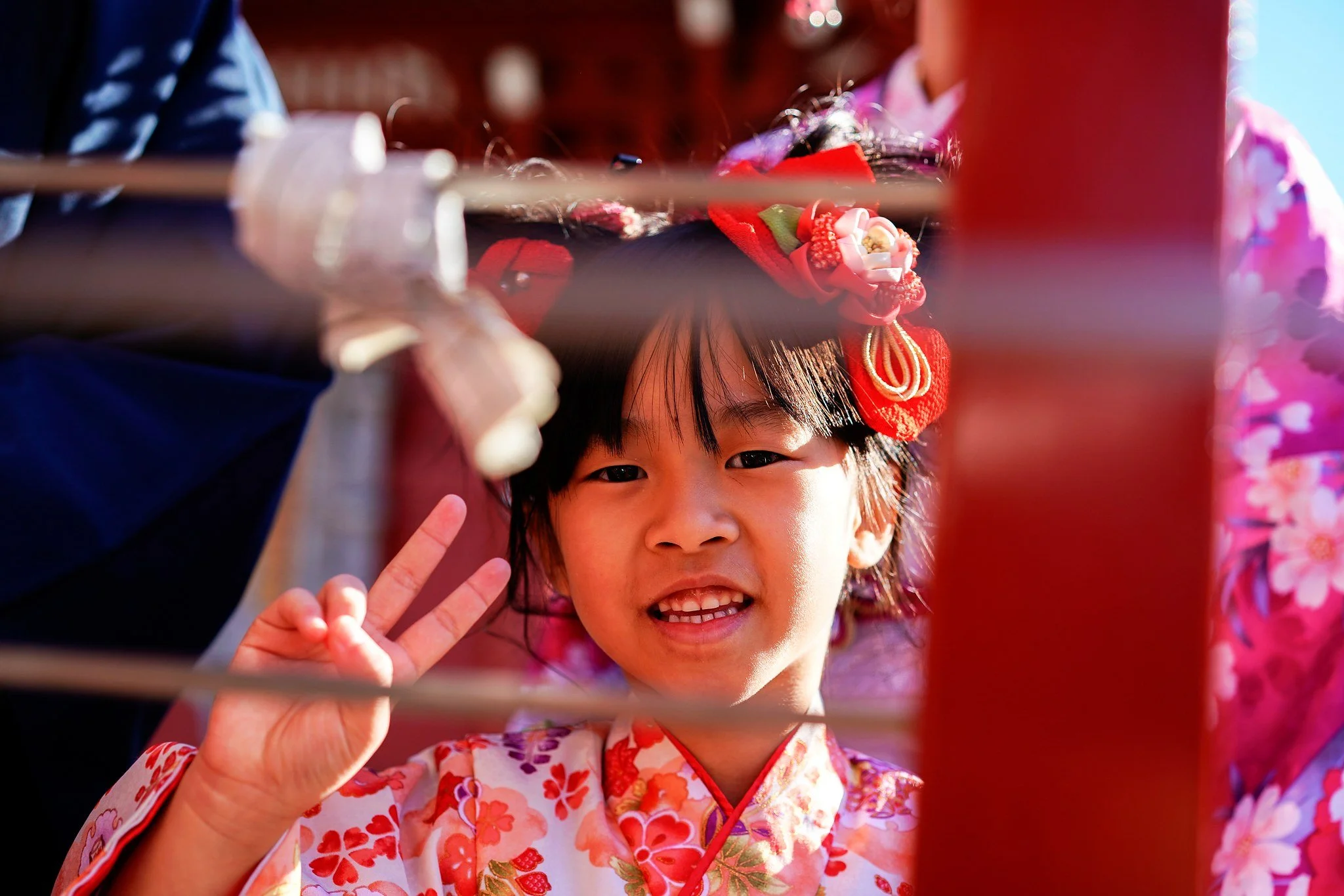 Little girl in kimono making a peace sign at Senso-ji, Asakusa