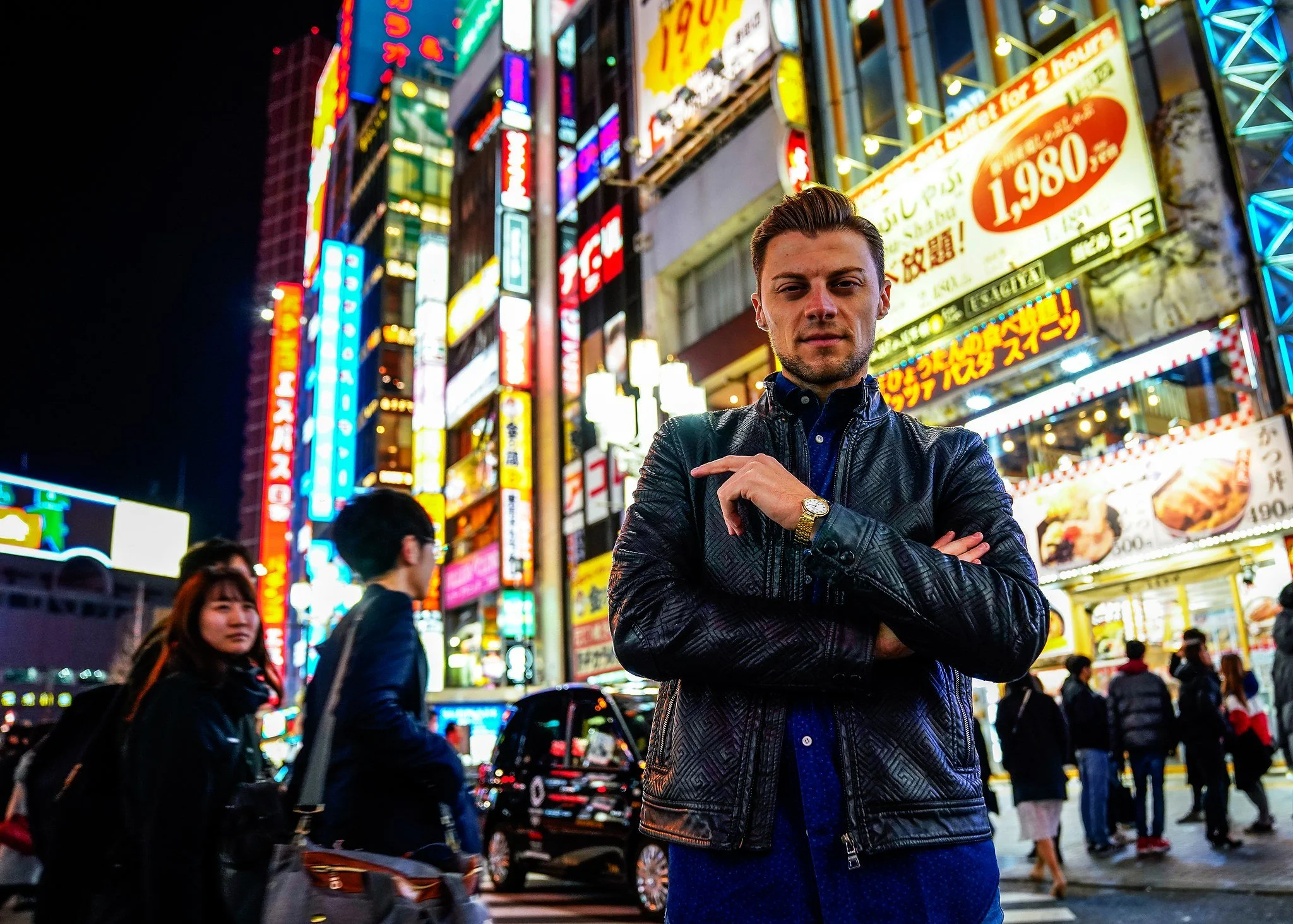 Man posing under Kabukicho neon signs in Shinjuku at night