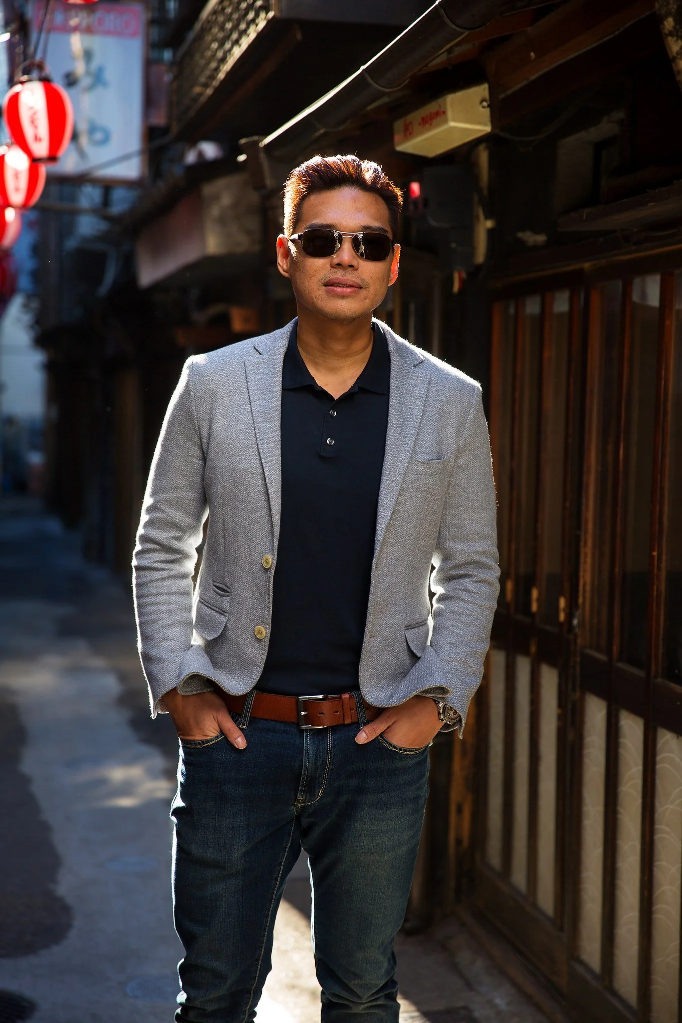 Man in a blazer and sunglasses in a sunlit Shibuya alley