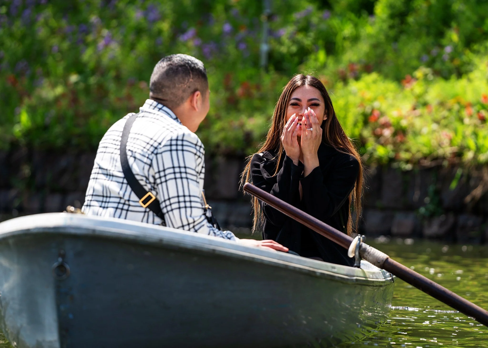 Woman covering her face in surprise during a rowboat proposal in Tokyo
