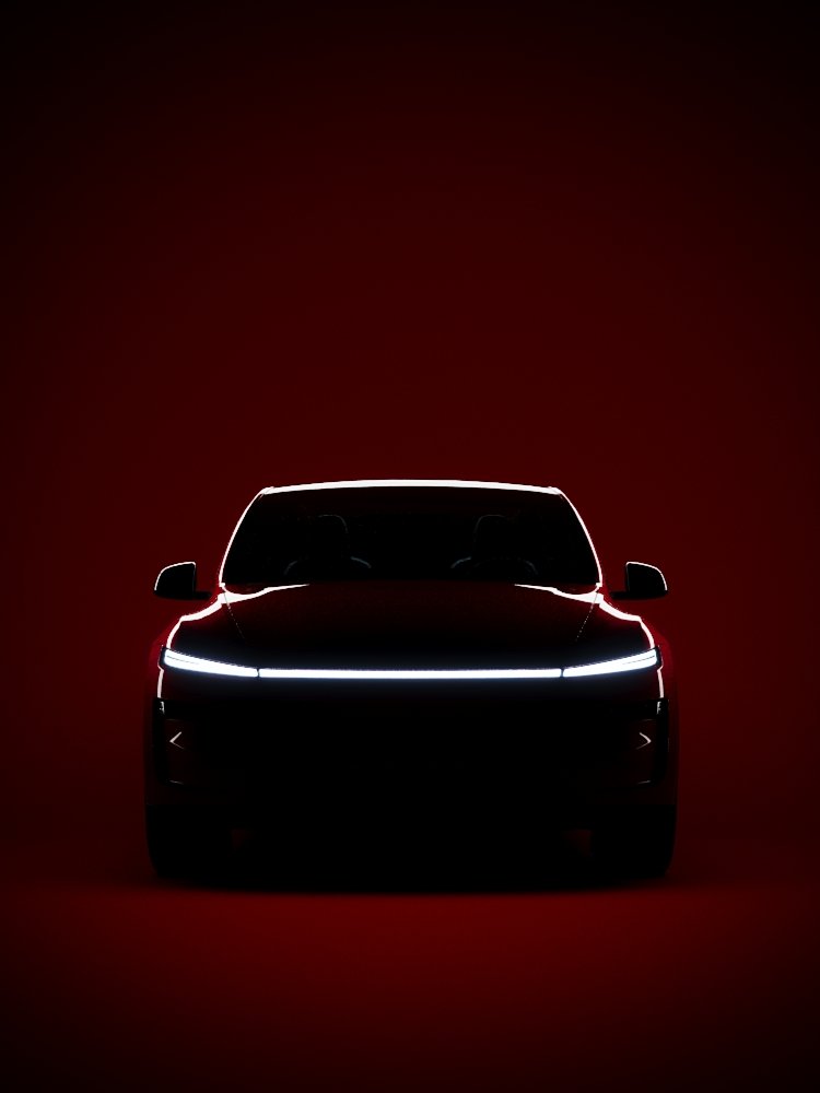 Front view of a black car with illuminated headlights on a red background.
