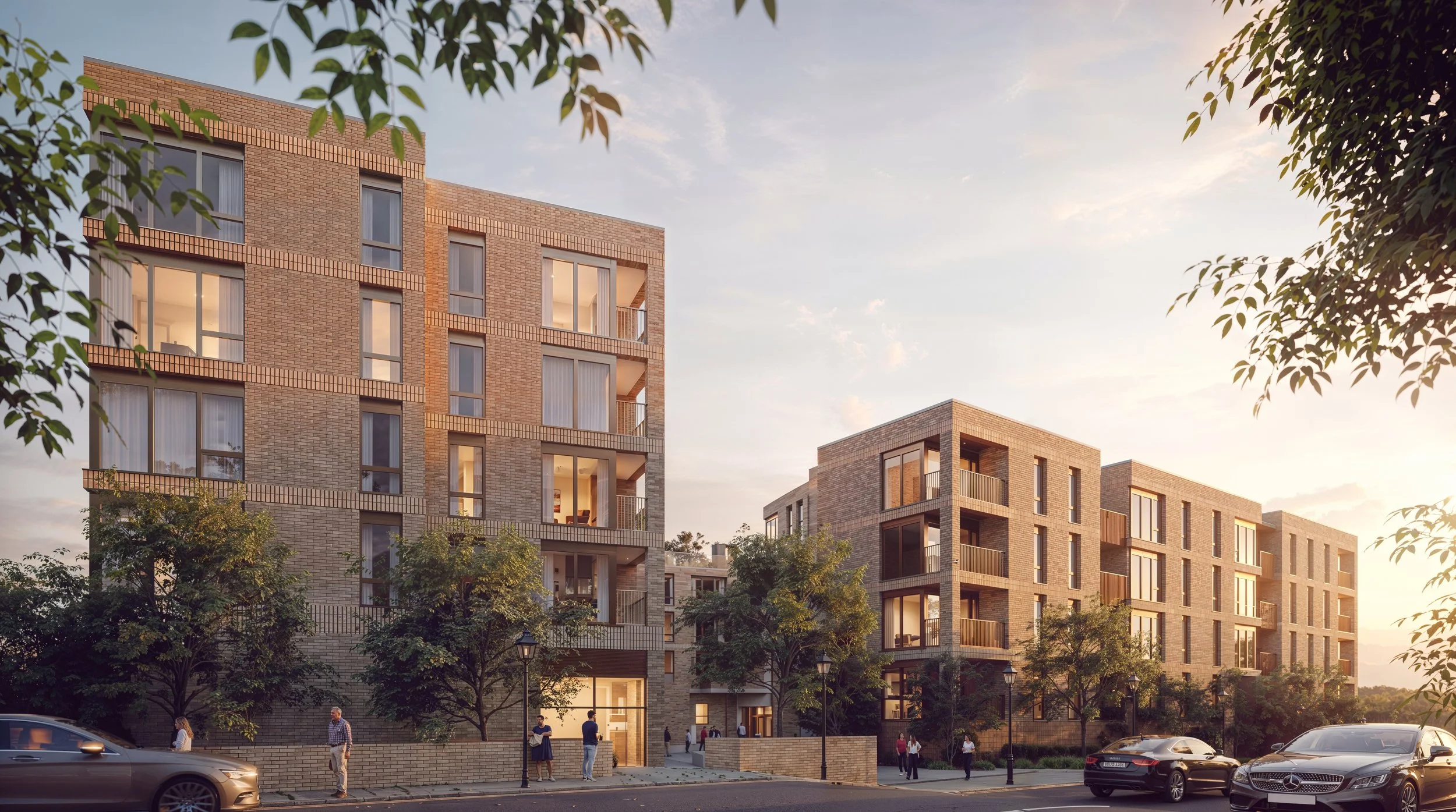Modern brick apartment buildings with large windows and balconies, trees lining the sidewalk, and people walking along the street during sunset.