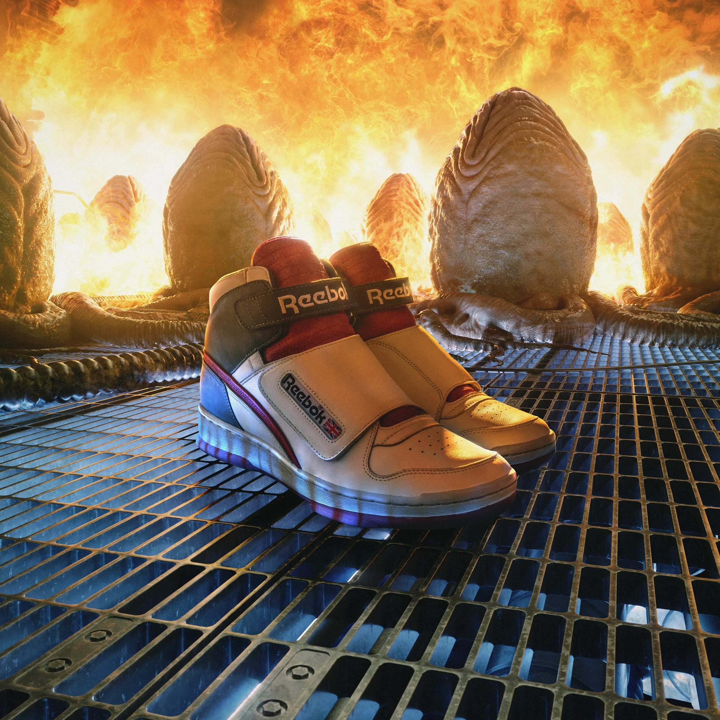 Pair of Reebok sneakers placed on metal grating with burning flames in the background.