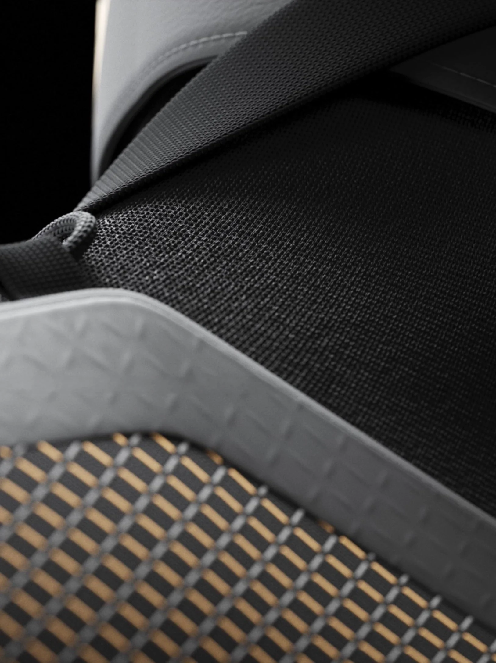 Close-up of a black, textured fabric with a curved surface, part of a shoe or sneaker, with a patterned sole visible at the bottom.