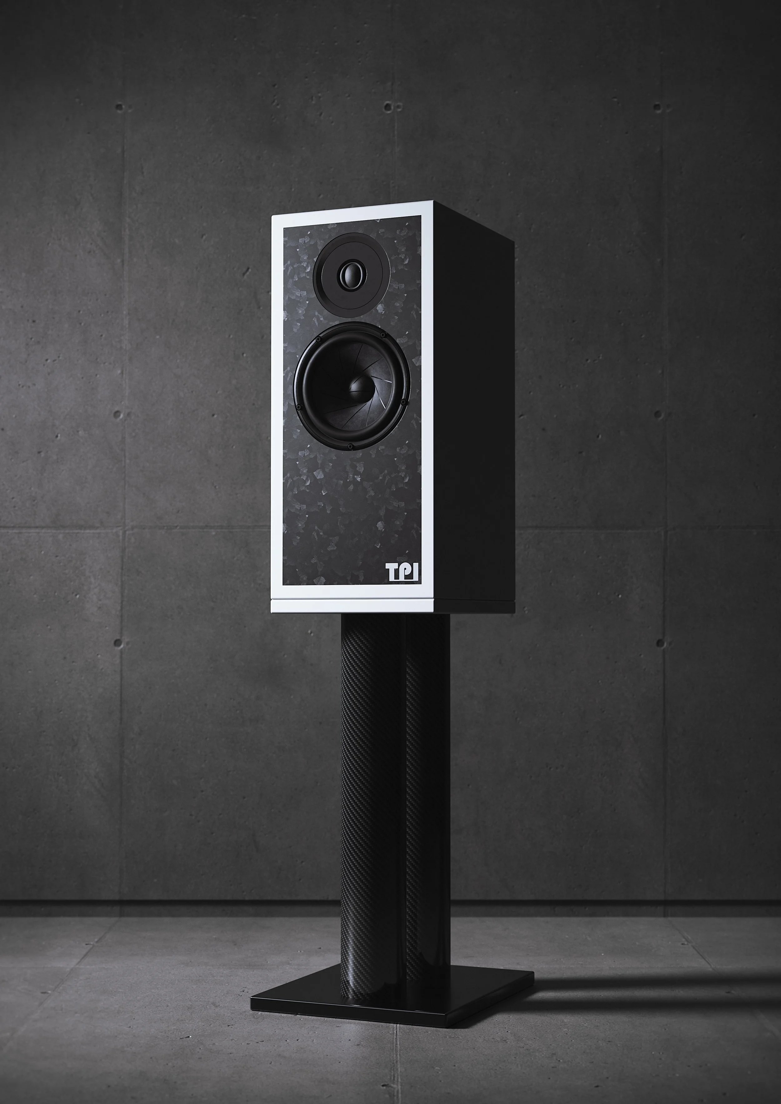 High-end black and white loudspeaker on a stand against a dark wall.