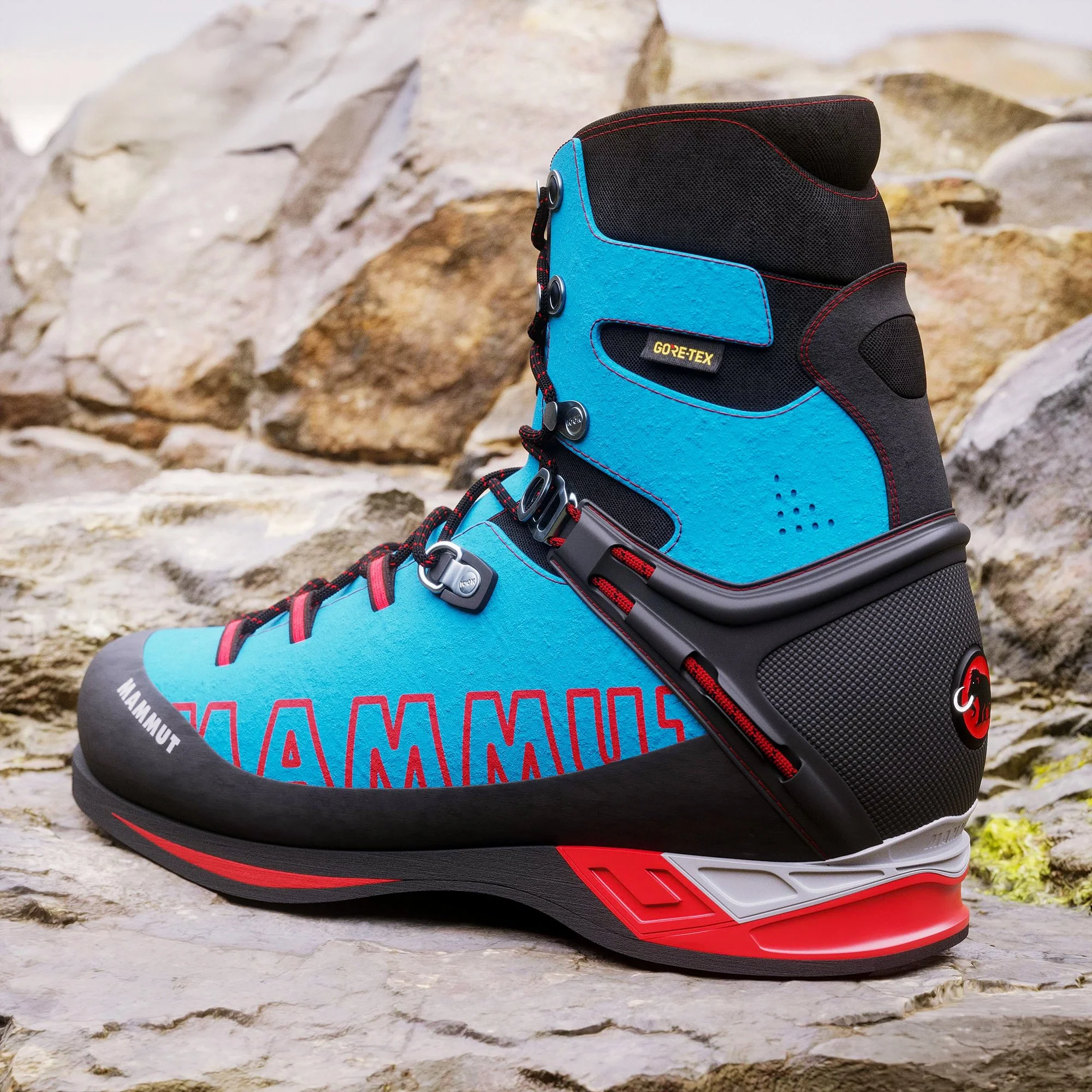 Close-up of a blue and black hiking boot with red laces and a GORE-TEX tag, placed on rocky terrain.