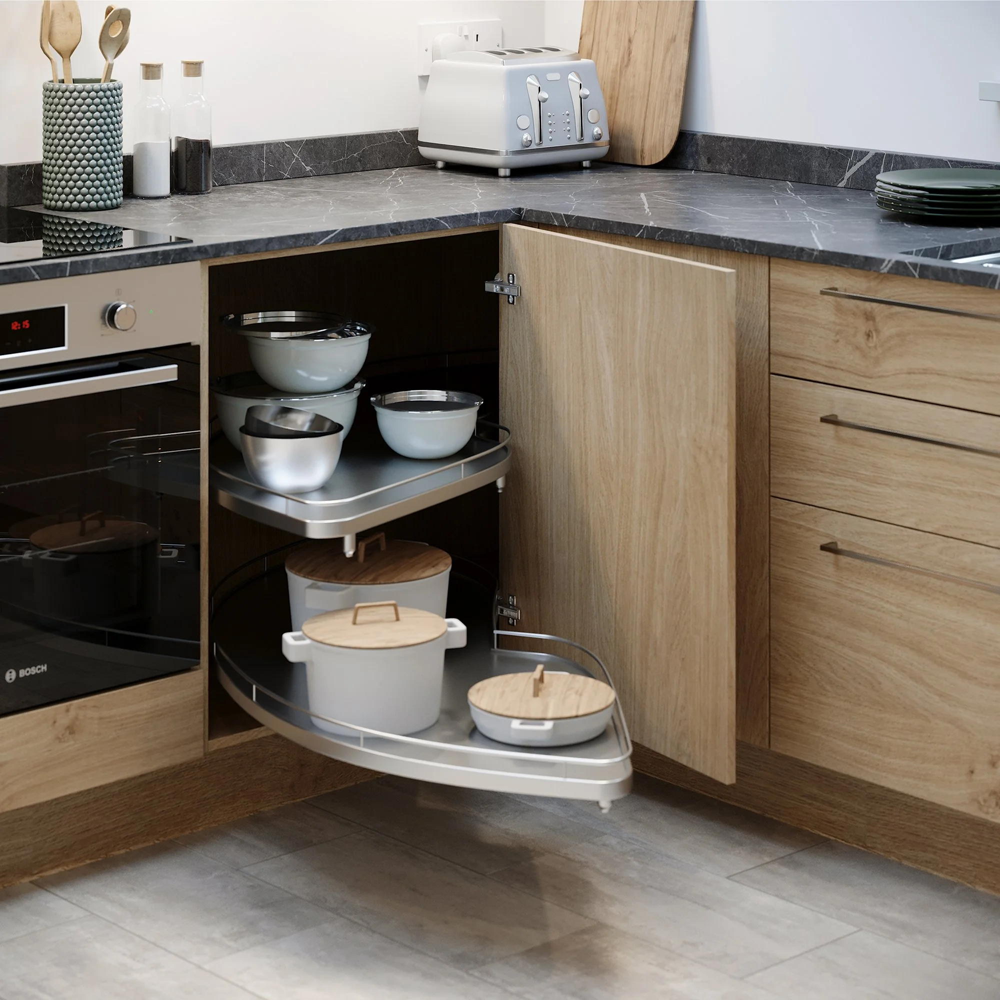 Kitchen countertop with a toaster, plates, bowls, and a wooden cutting board, with a closed cabinet below.