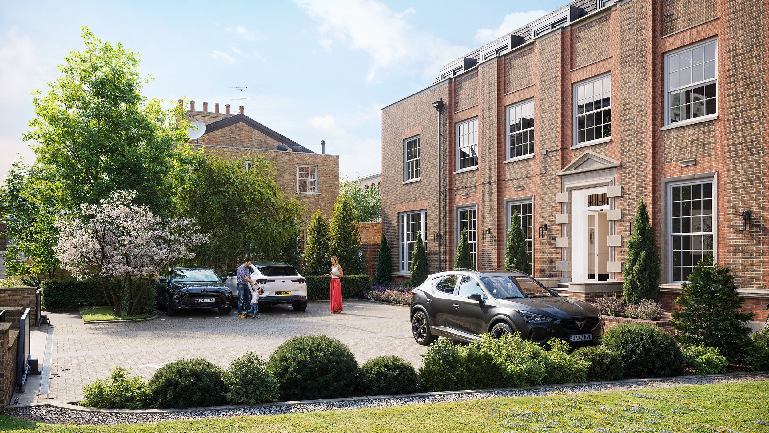 People standing and talking outside a modern brick apartment building with parked cars and trees.