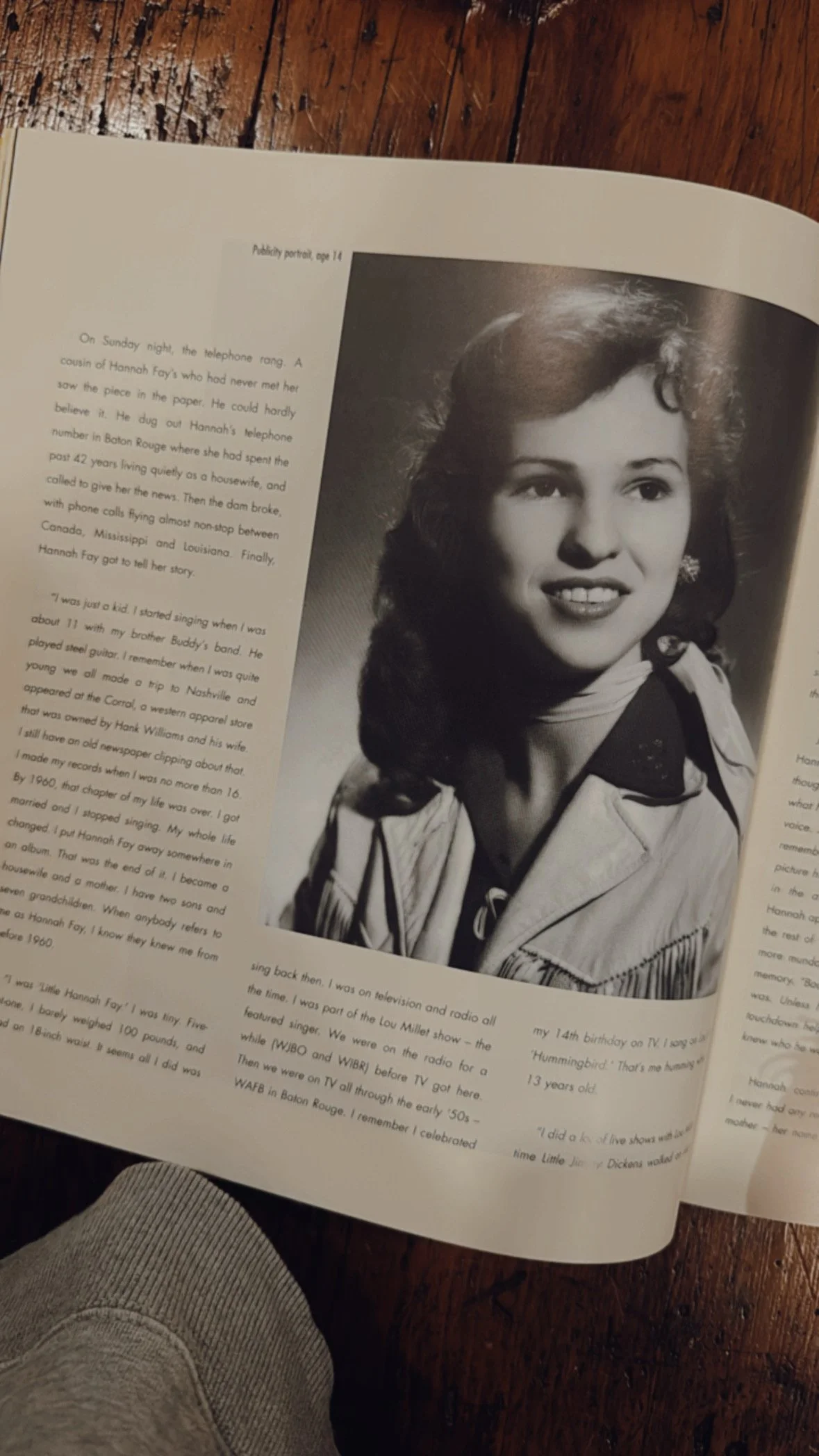 Black and white portrait of a woman with curly hair wearing a jacket and earrings, looking slightly to the side.
