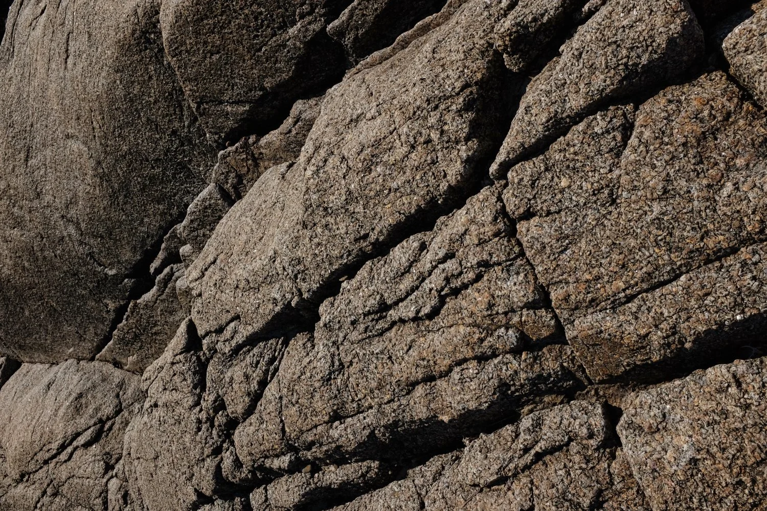 Close-up of textured gray and brown rocks with cracks and rough surfaces.