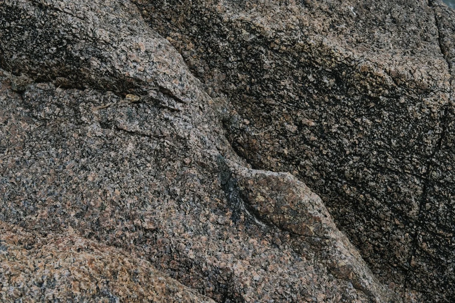 Close-up of textured granite rocks with rough surface and speckled appearance.