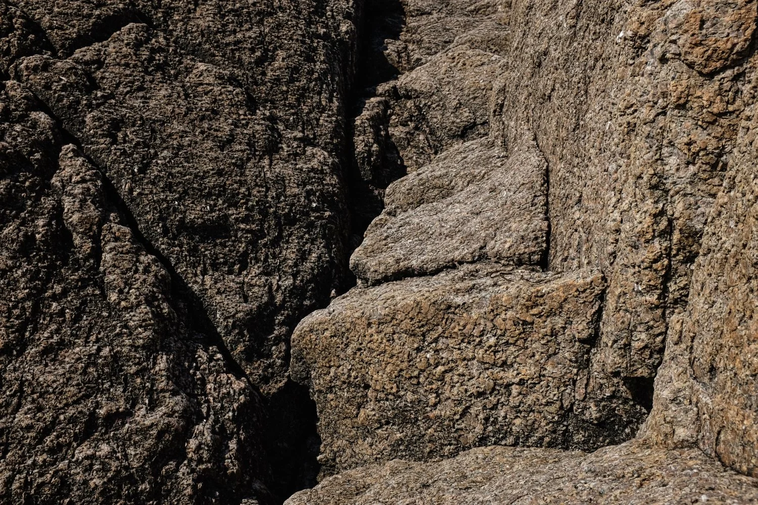 Close-up view of large, textured rocks with rough surfaces and natural cracks.