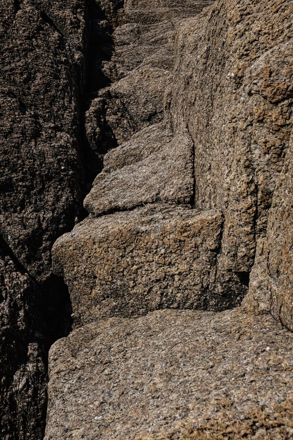 Close-up shot of textured, weathered rocks with rough surfaces and reddish-brown coloration.