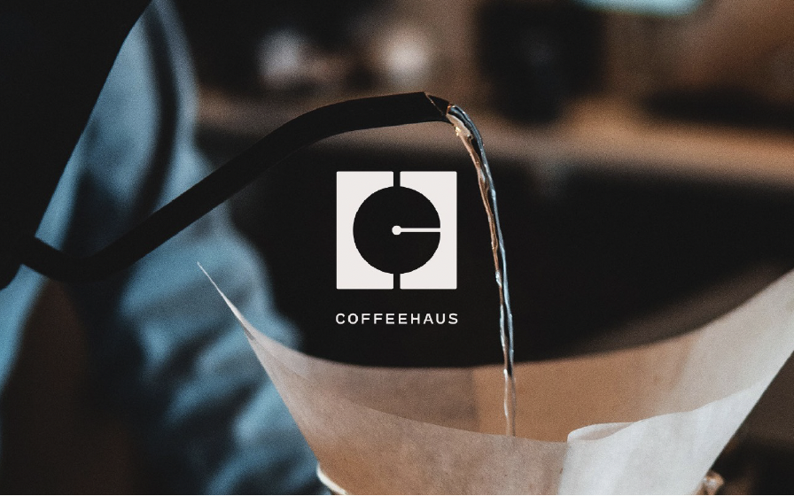 A coffee brewing cone with hot water pouring over coffee grounds, with a Coffeehaus logo on it.