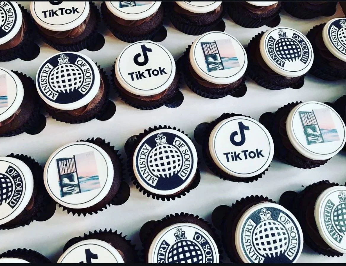 Cupcakes with edible toppers featuring the logos of the Ministry of Sound, TikTok, and the Reef.