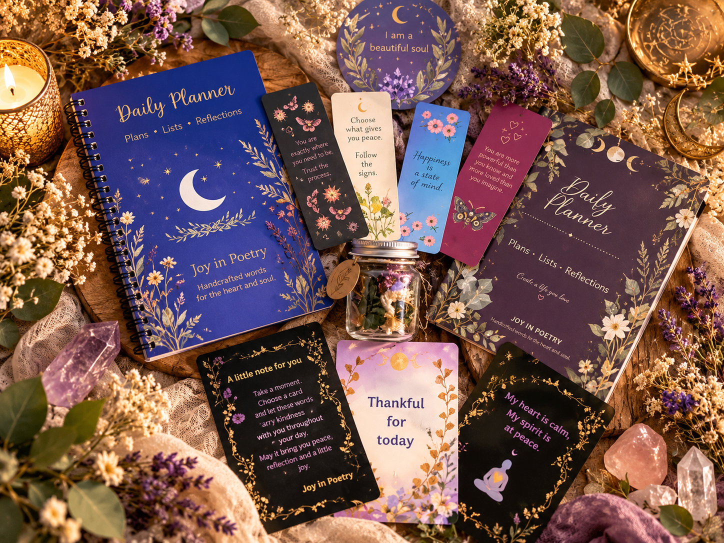 Joy in Poetry handcrafted planners, affirmation cards, and poems in a jar displayed with flowers and crystals.