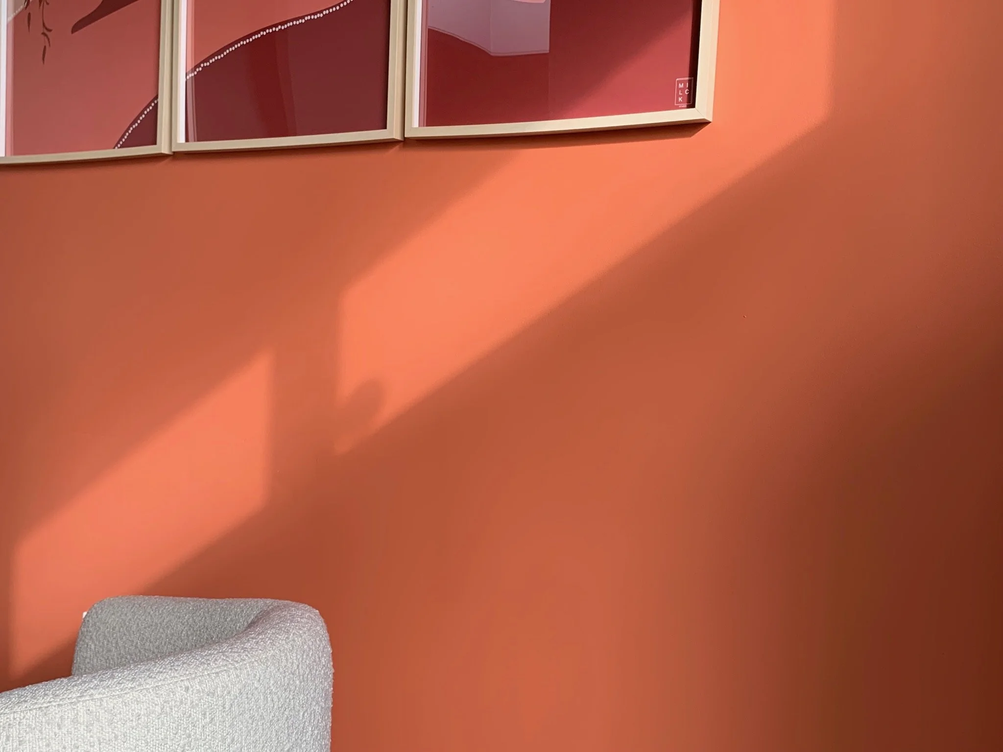 Een een oranje muur met lichtinval.