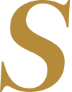 Close-up of a stylized, gold-colored letter 'S' on a black background.