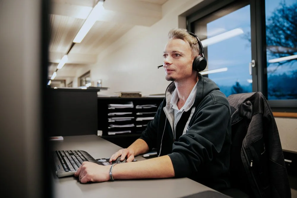 Mann im Büro mit Kopfhörern am Computer