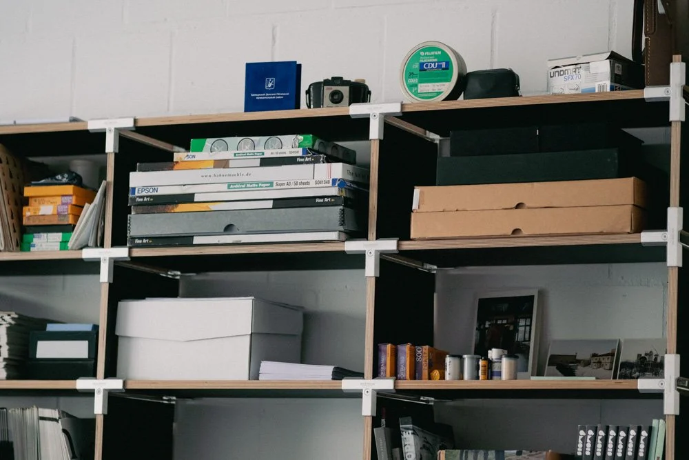Regale mit Büchern, Akten, Papiere, Verpackungen und Bürozubehör in einem Arbeitszimmer oder Büro.