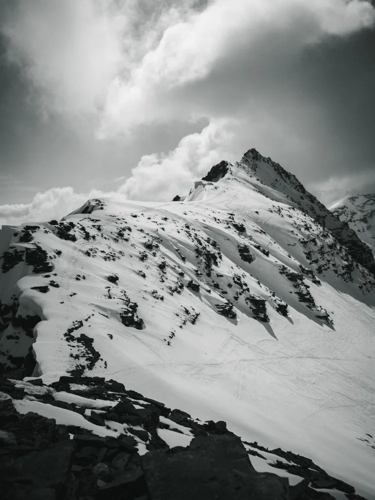 Schneebedeckte Berge mit Wolken am Himmel.
