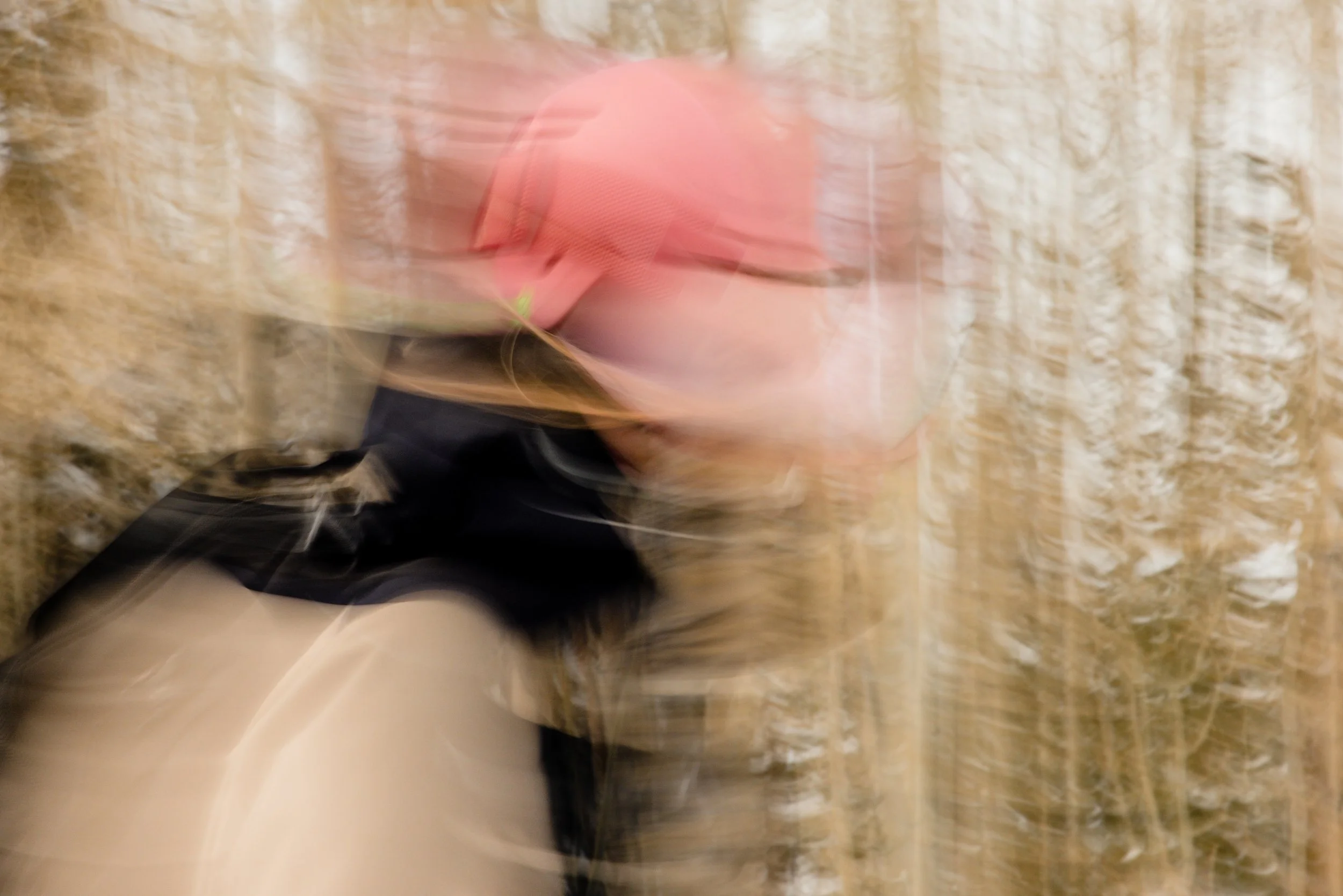 Blurred image of a skier as she skis through aspens.