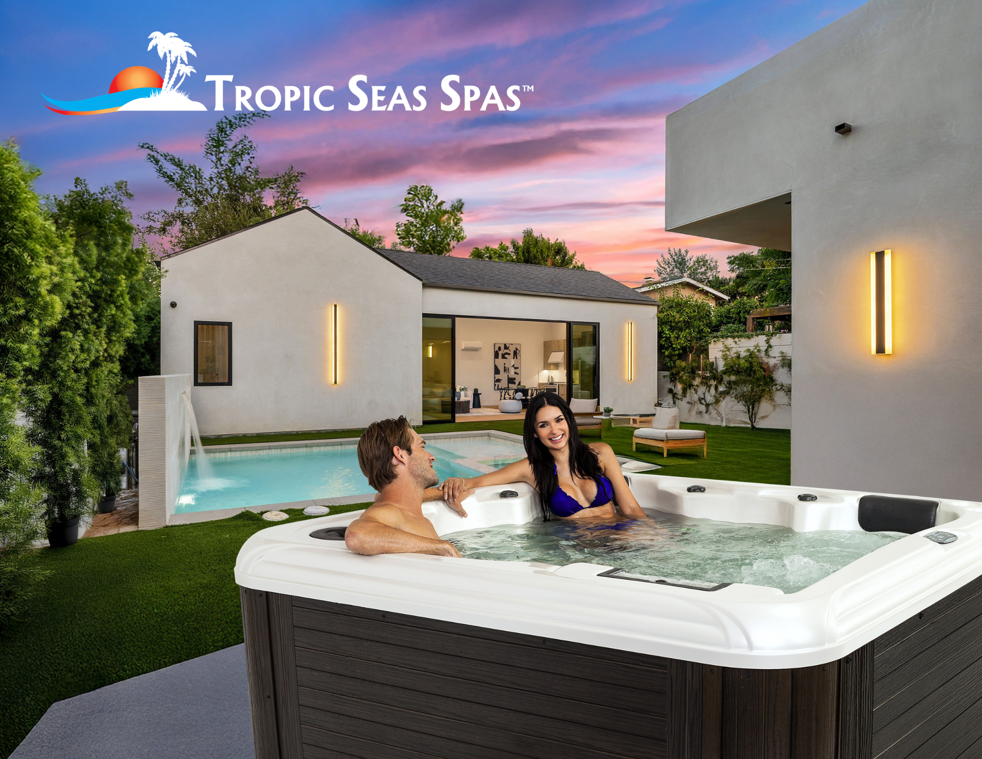 Two people relaxing in a hot tub in a backyard with a modern house, a swimming pool, lush green trees, and a colorful sunset sky.