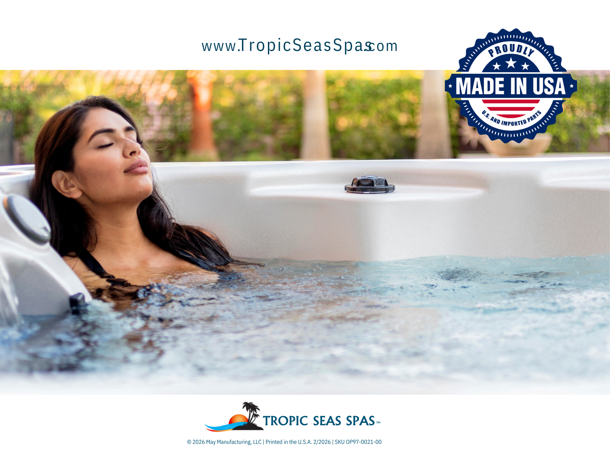 A woman relaxing in a hot tub outdoors with greenery and trees in the background, featuring a logo for Tropic Seas Spas and a badge indicating it is made in the USA.