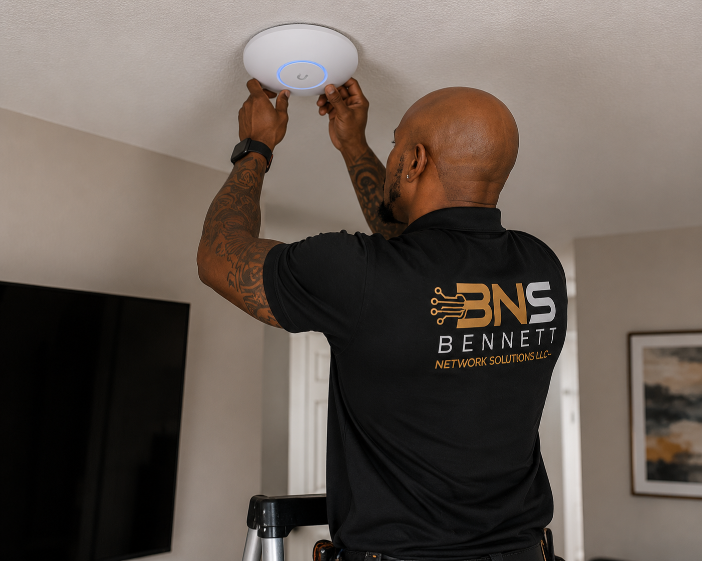 Bennett Network Solutions technician installing a ceiling-mounted Wi-Fi access point
