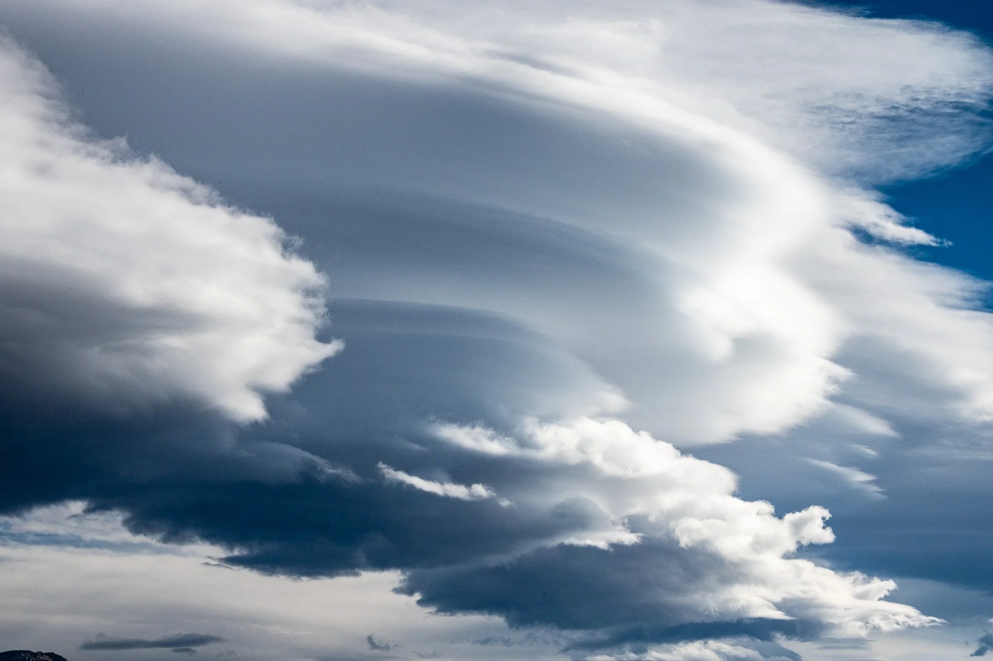 Overcast sky with dark, thick clouds and patches of blue sky visible behind them.