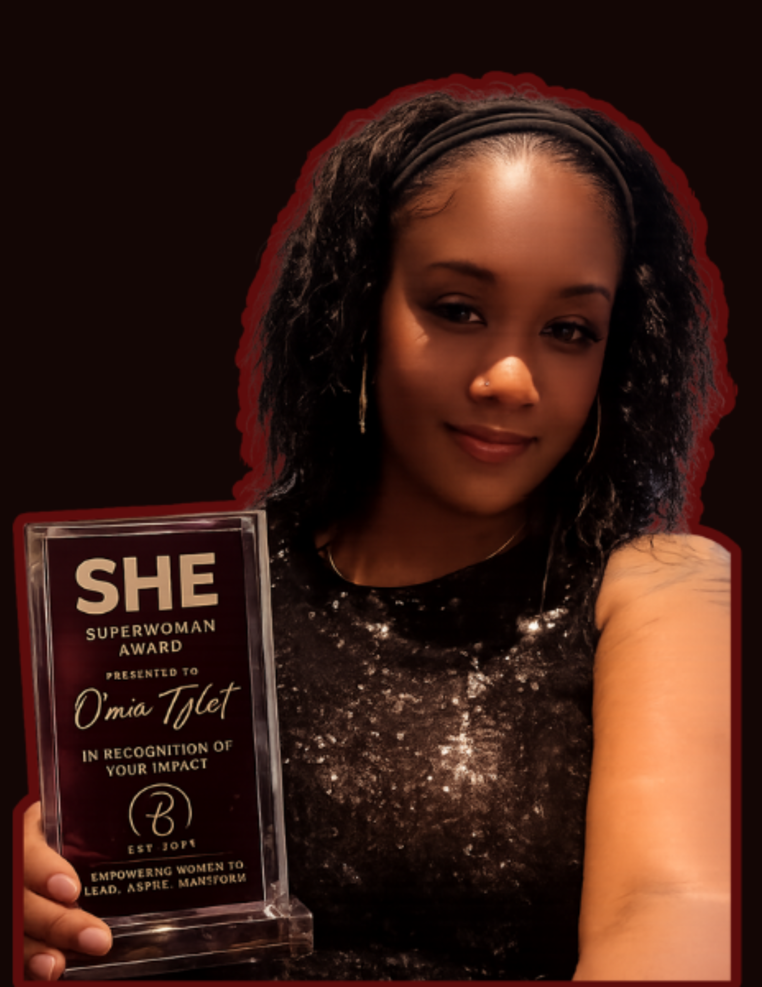 A woman with curly hair and a black headband holding a glass award that reads 'SHE Superwoman Award presented to O'mia Tjlet in recognition of your impact'