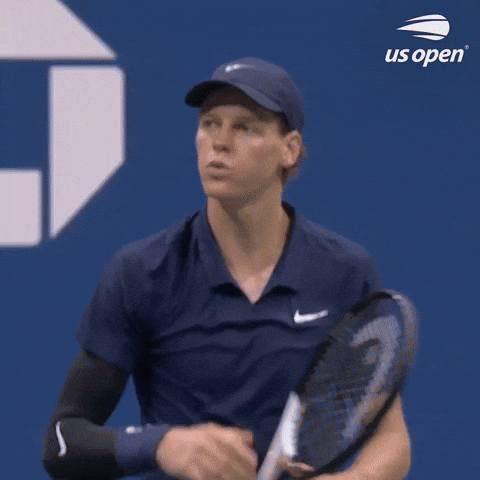 Young female tennis player in navy blue Nike outfit holding tennis racket at US Open.