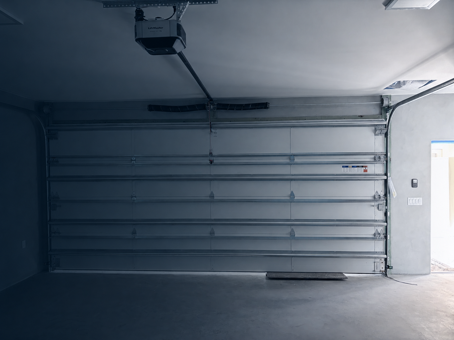 Interior view of a residential sectional garage door and torsion counterbalance system.