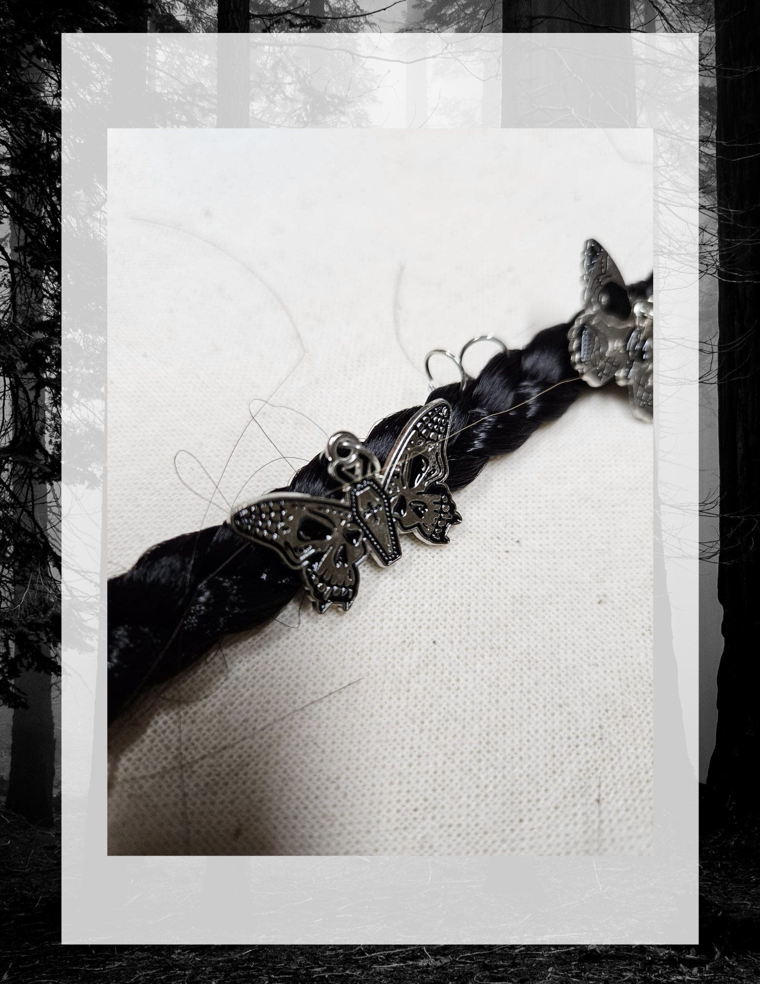 Gros plan charm papillon sur tresse noire, anneaux visibles