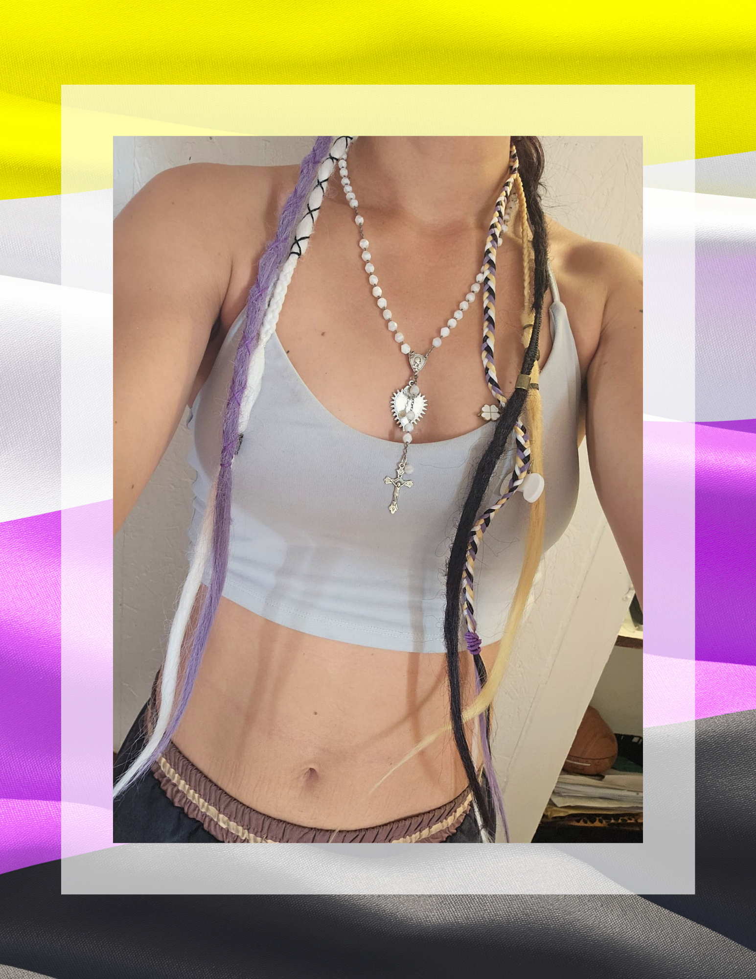 Détail ponytail pride sur crop top gris, breloques trèfle et cœur