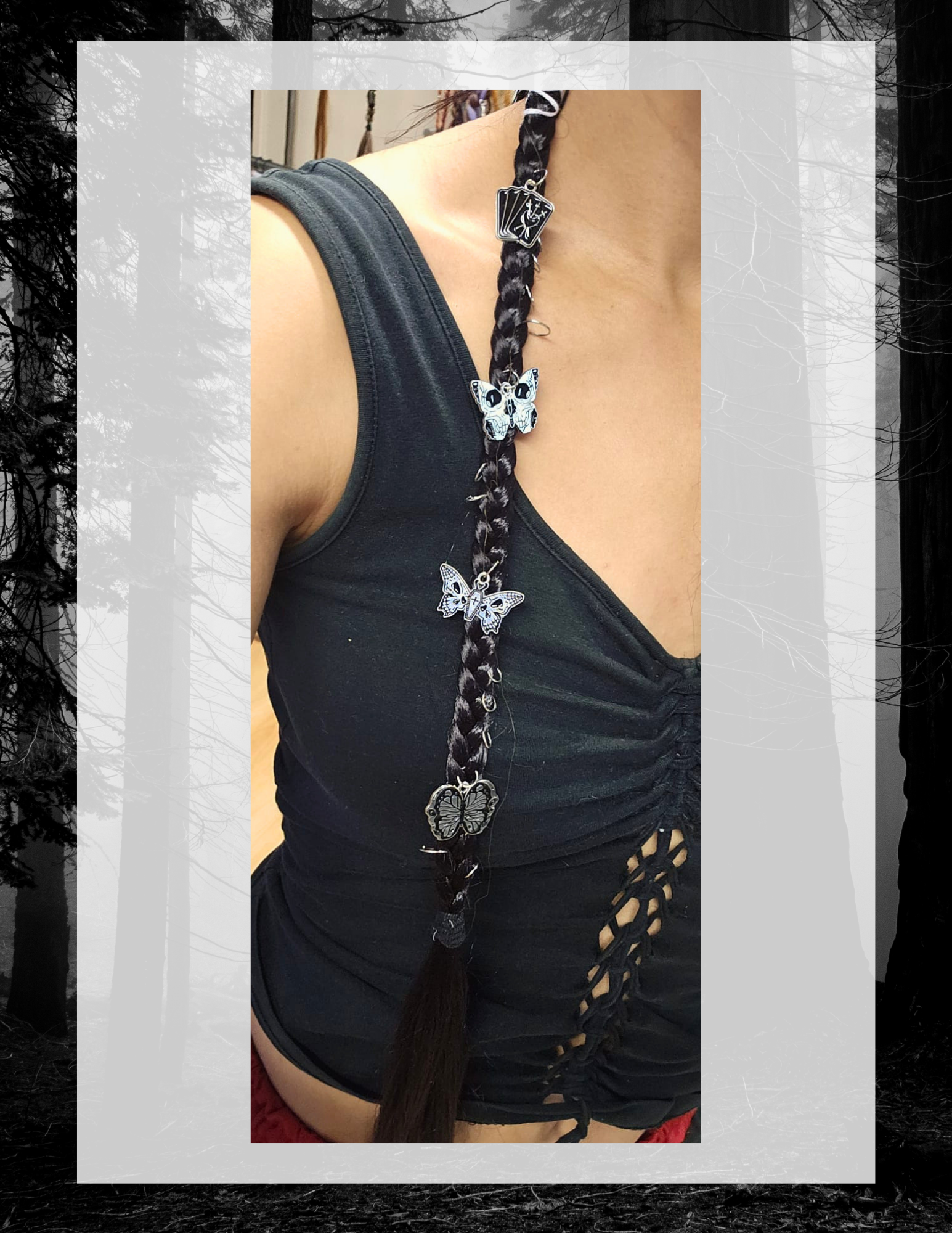 Tresse noire portée sur haut noir, charms papillons et tarot