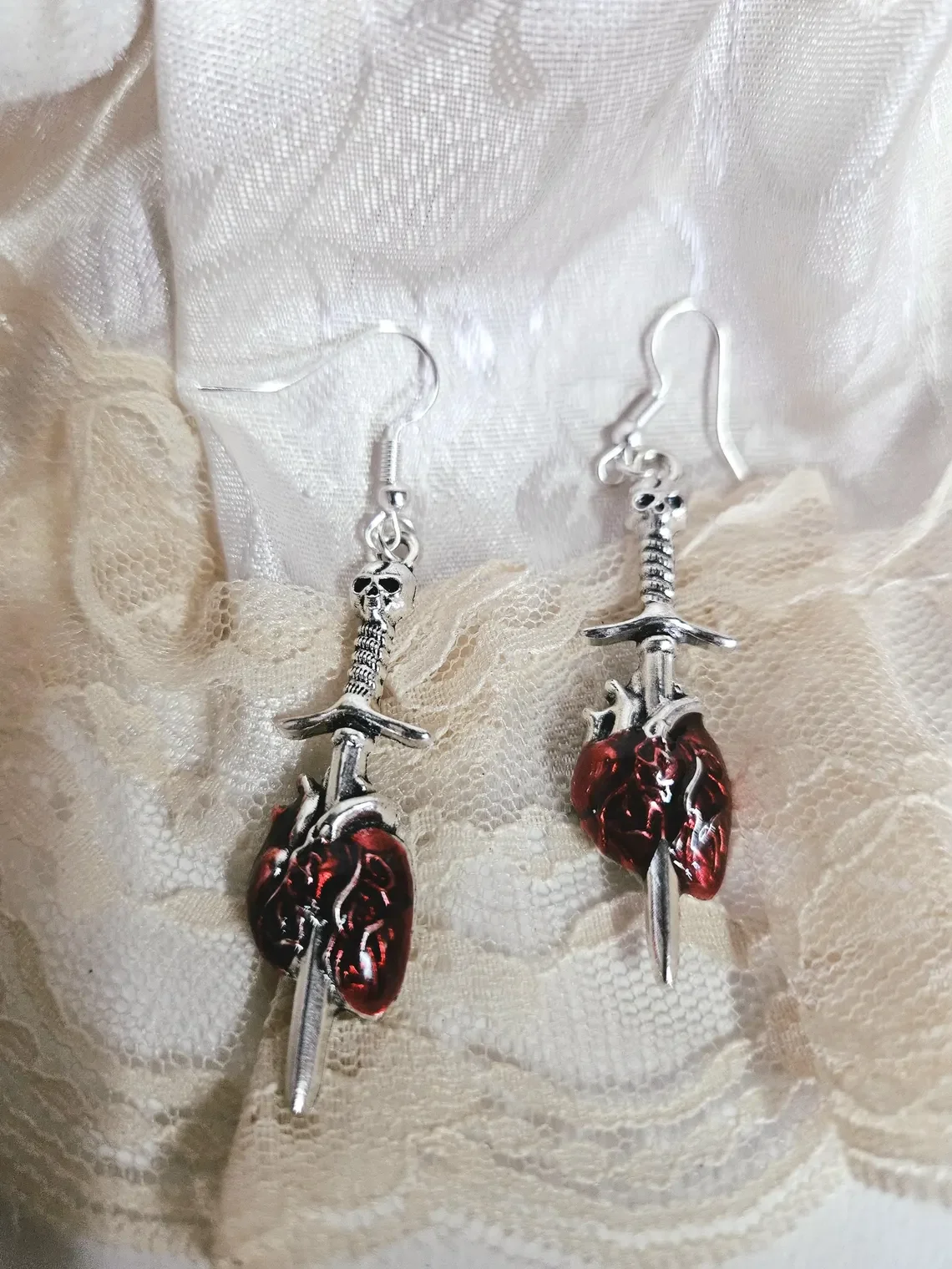 vBoucles d'oreilles argentées et rouges portées, détail gothique