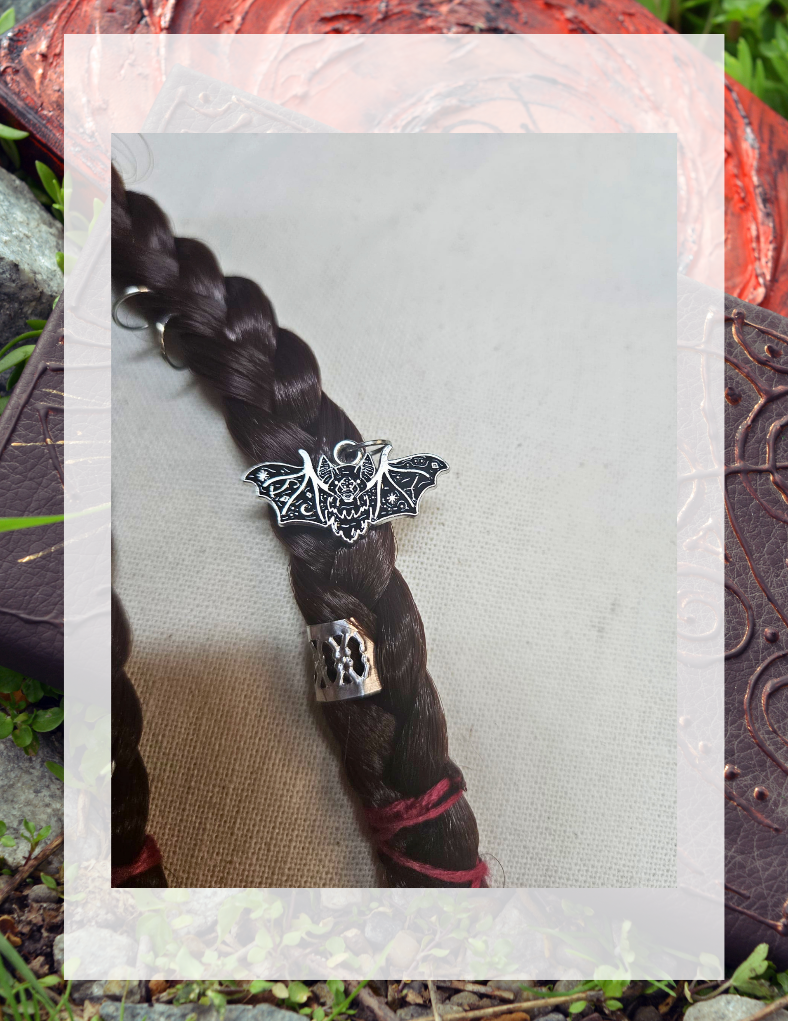 Gros plan charm chauve-souris gothique sur tresse brune