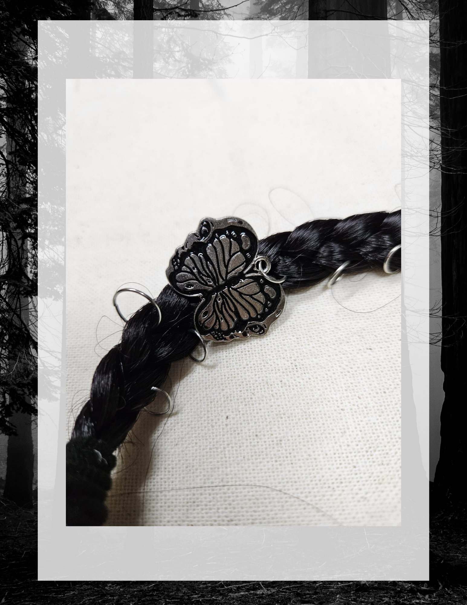 Détail charm papillon-crâne argenté sur tresse noire