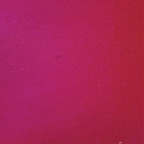 Close-up of a pink and red gradient surface with a textured appearance.