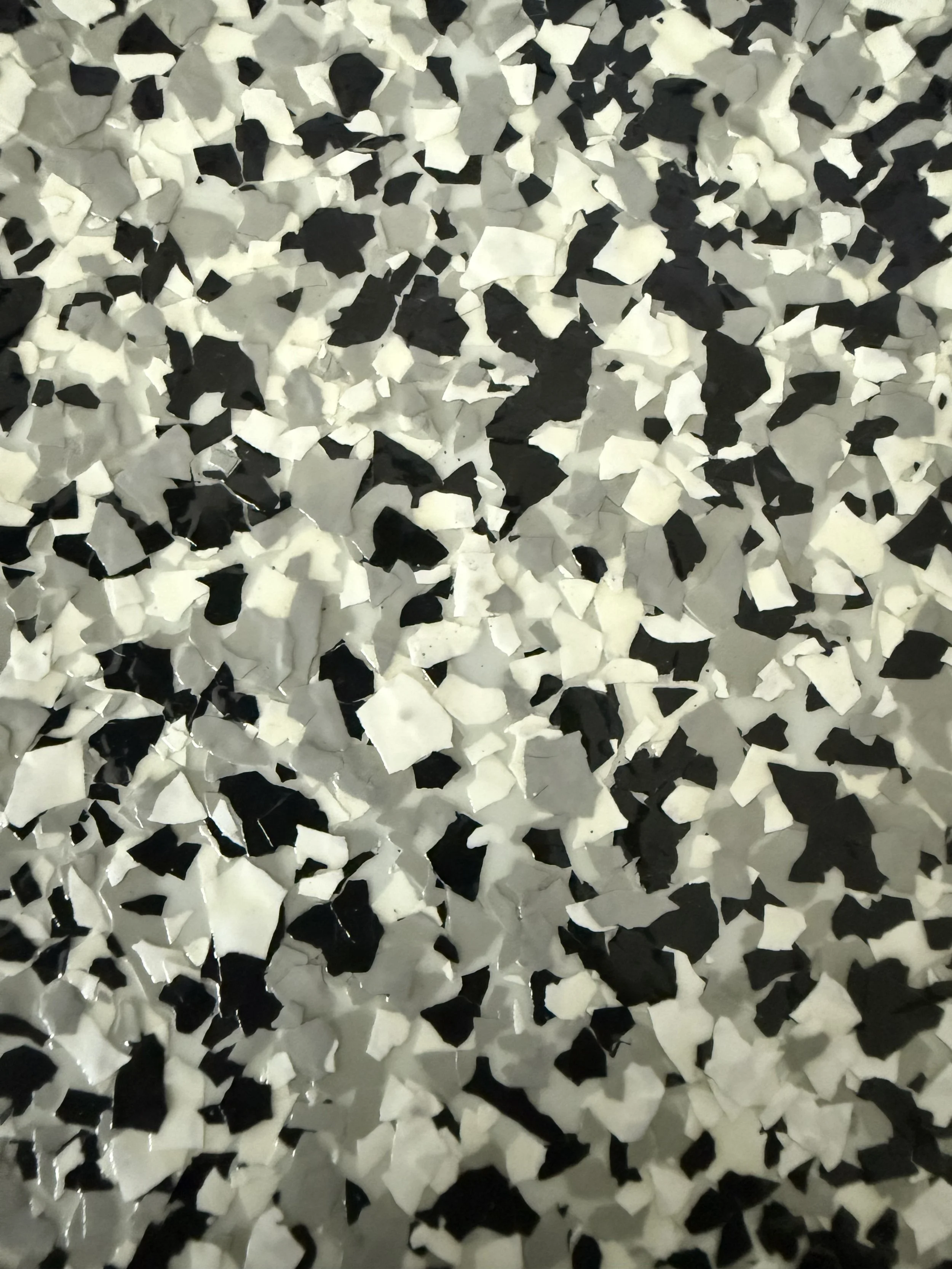 Close-up of black, white, and gray mosaic tiles with irregular shapes.