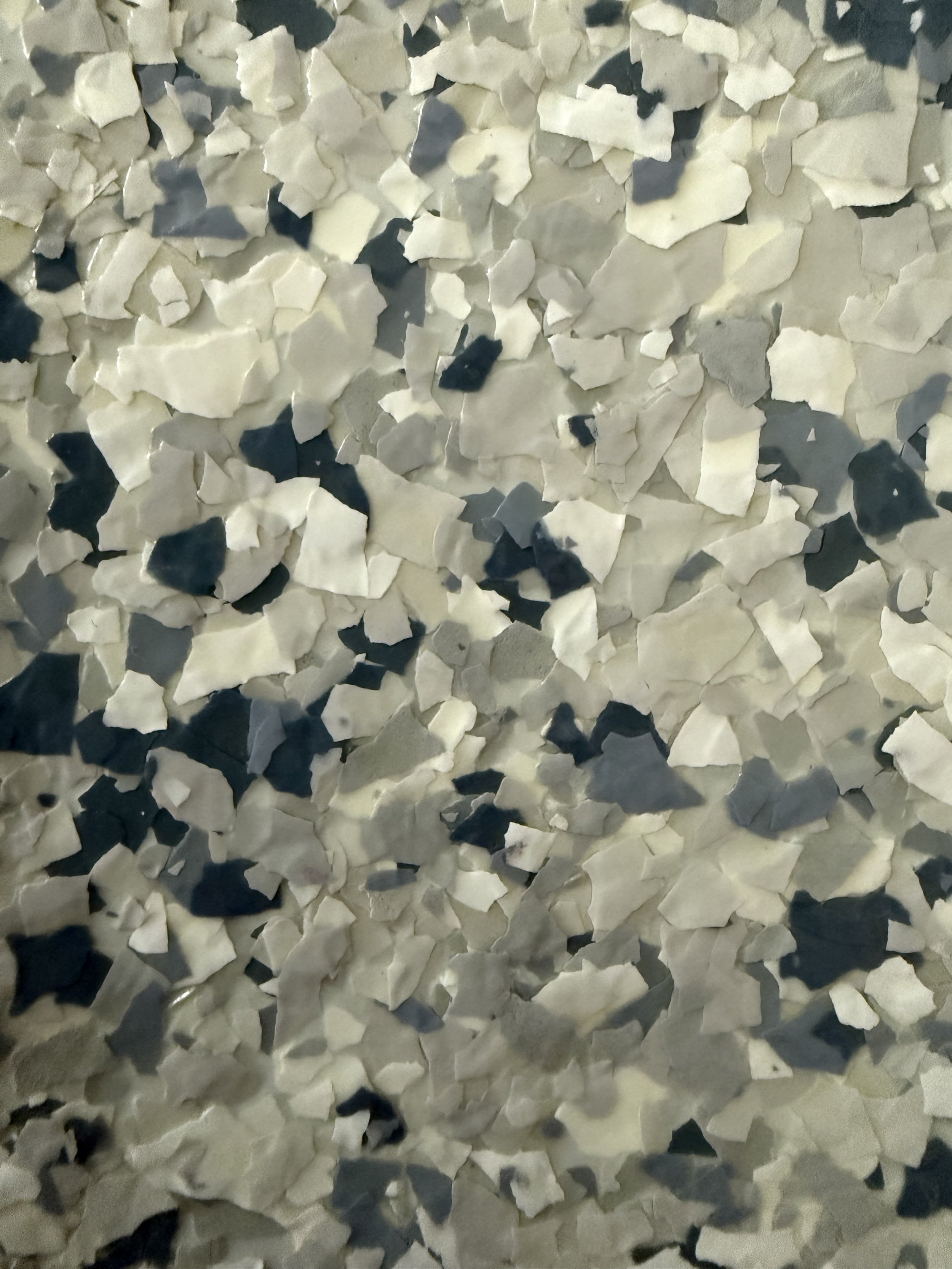 Close-up of dispersed black and white irregularly shaped ceramic or stone fragments.
