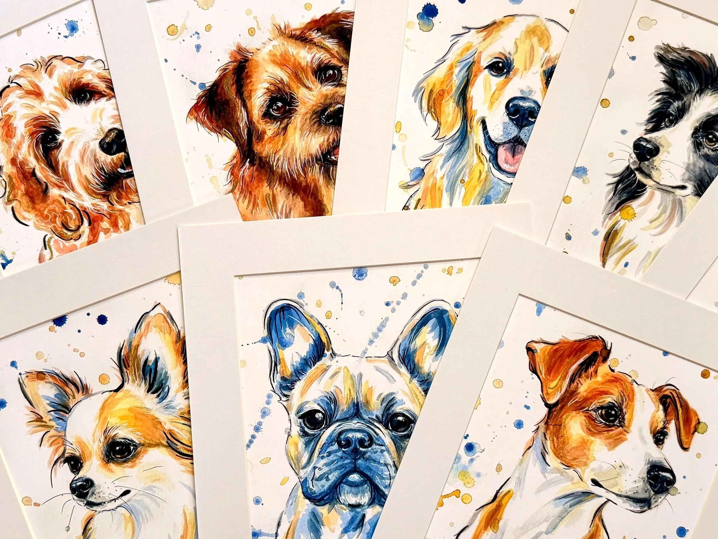 Series of watercolor paintings of different dogs, some with splashes of blue and gold, all showing varied dog breeds with expressive faces.