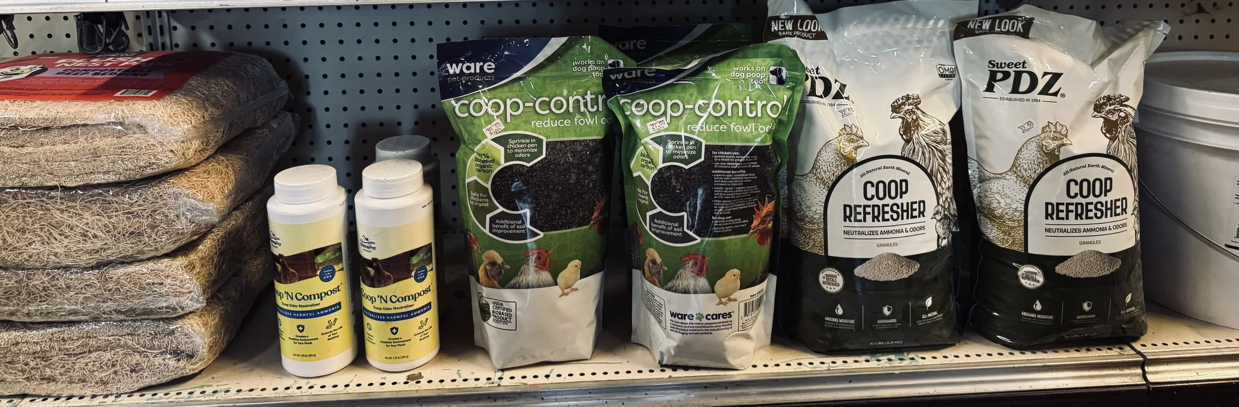 Shelves with pet care products including cat litter, chicken manure pellets, and soil conditioners.