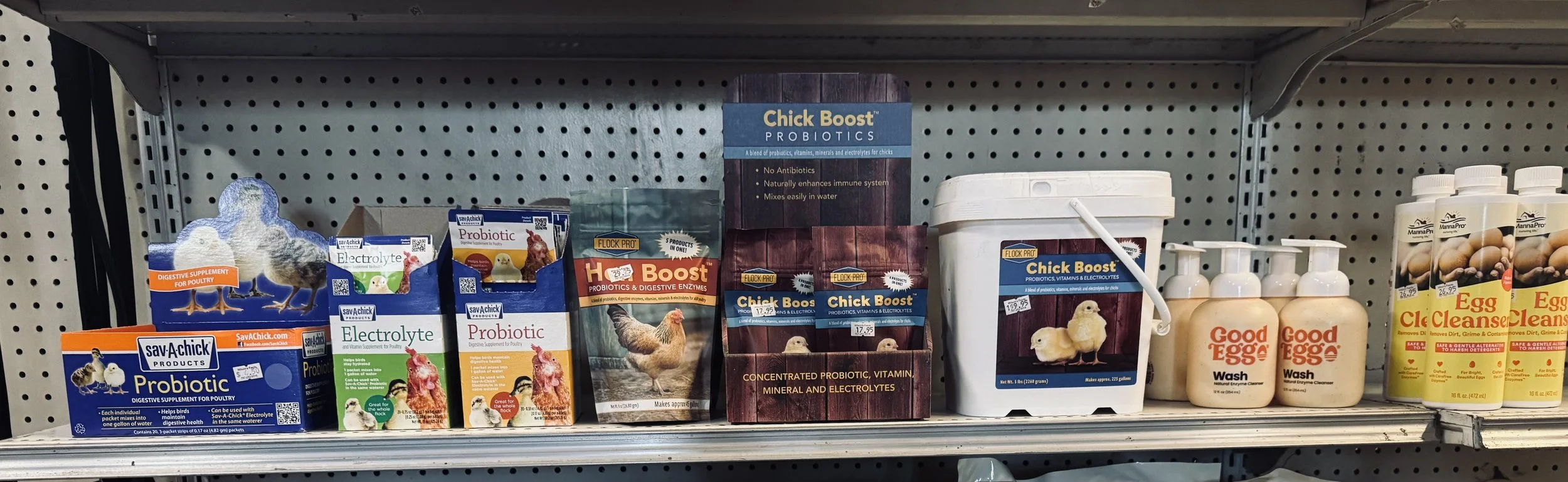 Shelf with poultry supplements, probiotics, electrolytes, and egg cleaning products for chickens.